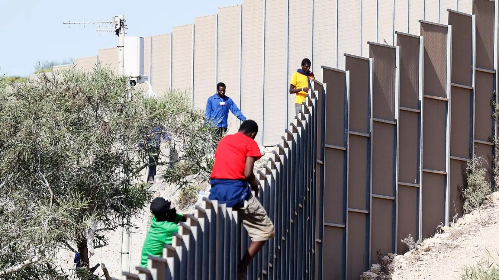 Migranten klettern über einen Zaun auf der Insel Lampedusa. (Foto: Cecilia Fabiano/LaPresse via ZUMA Press/dpa)