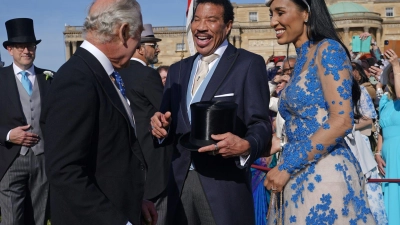 König Charles III. (l) spricht während der Gartenparty im Buckingham Palace mit Lionel Richie (M) und Lisa Parigi. (Foto: Yui Mok/PA Wire/dpa)