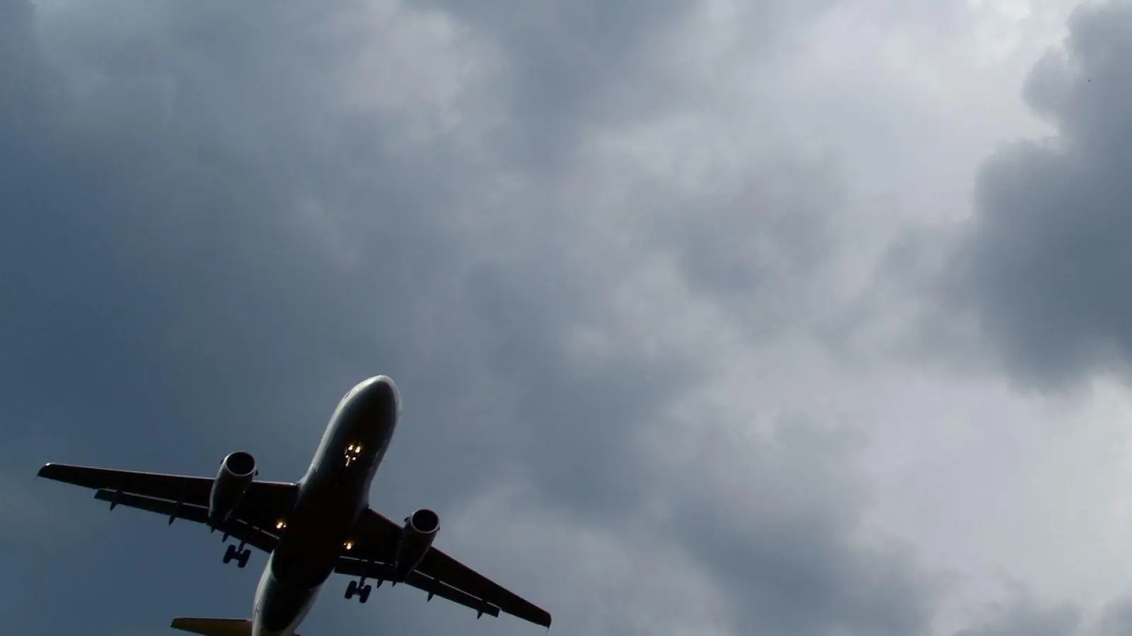 Gewitterwolken türmen sich über einem Flugzeug auf. (Foto: Federico Gambarini/dpa)