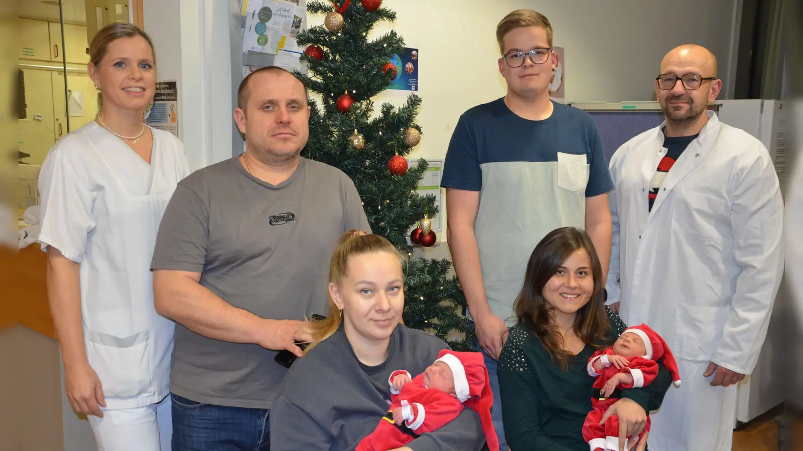 Kinderkrankenschwester Julia Kuhr, Papa Serhii und Mama Oleksandra mit Angelina Parliuchenko, Papa Florian Sauerbier mit Mama Lorena und Alia im Arm sowie Chefarzt der Gynäkologie Dr. Norbert Maczo (von links) vor dem Christbaum der Klinik. (Foto: Christa Frühwald)