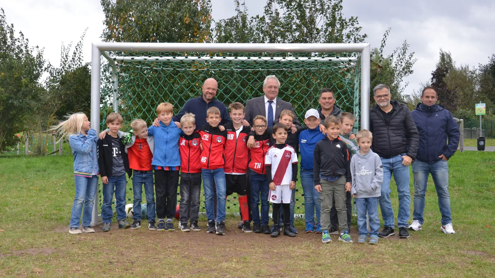 Mannschaftsfoto mit Bürgermeister und Verwaltung: Die Jugend hat den neuen Klinger-Bolzplatz schon in Beschlag genommen, die Erwachsenen (oben von links) durften mit aufs Bild: Alex Hajek als Vertreter der Anwohner, Bürgermeister Klaus Meier, Martin Hufnagel sowie Gerald Schorr und Frank Maes vom Bauamt. (Foto: Patrick Lauer)