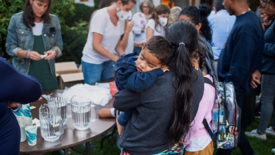 Aus ihrer lateinamerikanischen Heimat geflohene  Menschen stehen vor einer Kirche auf Martha&#39;s Vineyard. Der republikanische Gouverneur von Florida, Ron DeSantis, hat sie dorthin bringen lassen. (Foto: Ray Ewing/Vineyard Gazette/dpa)