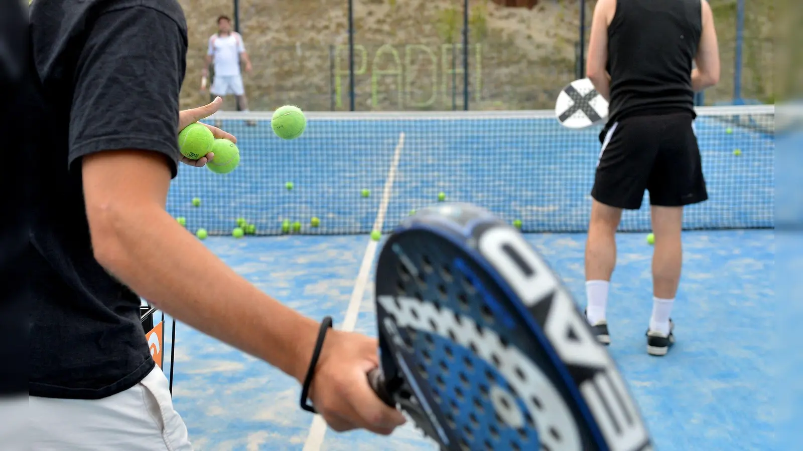 Mischung aus Tennis und Squash: Padel wird in einer Art Käfig gespielt, dessen Wände aus Glas oder Drahtgitter bestehen.  (Foto: Britta Pedersen/dpa-Zentralbild/dpa-tmn)