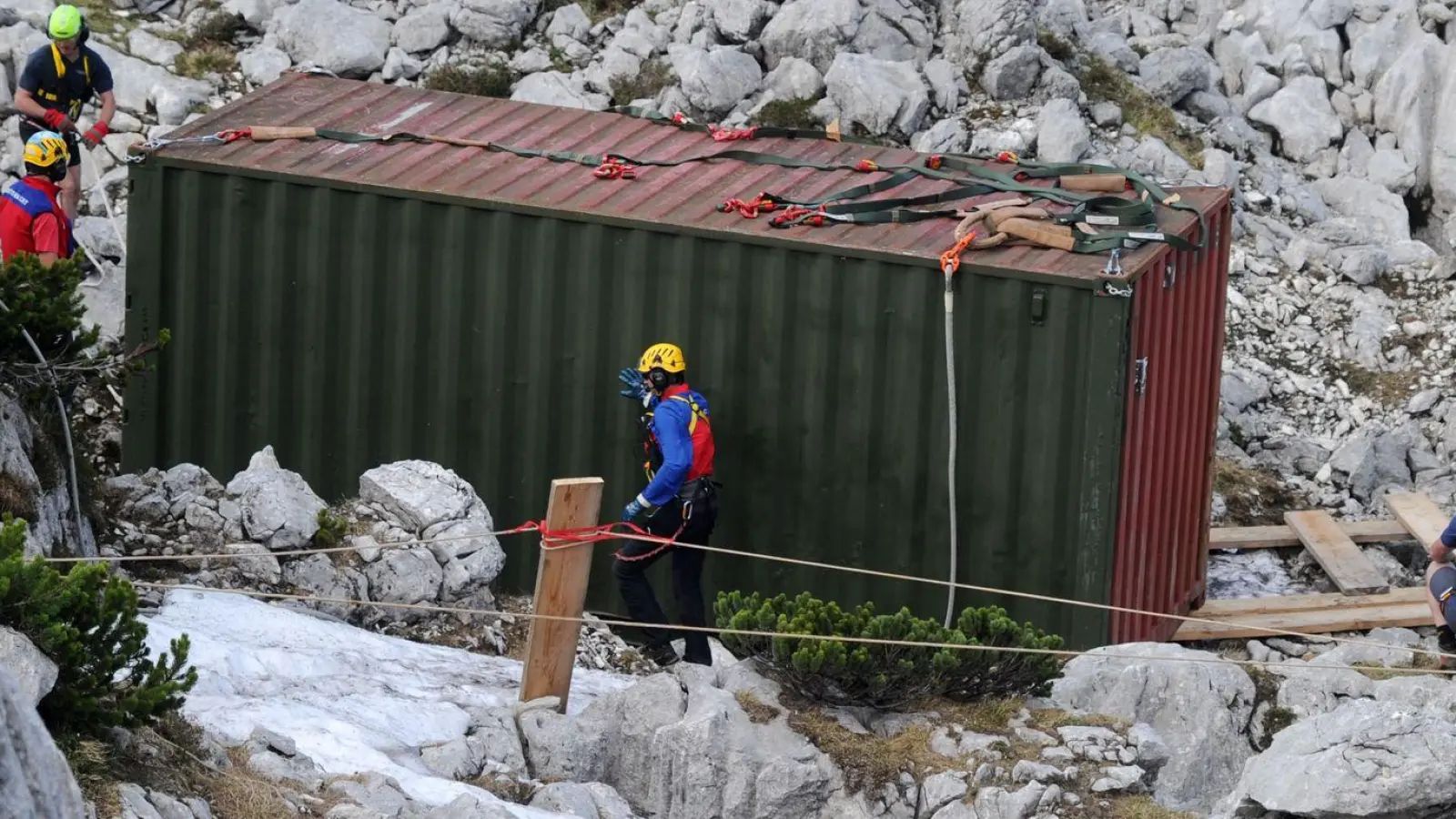 Einsatzkräfte stehen am Untersberg am Einstieg der Riesending-Schachthöhle bei einem Container. (Foto: Tobias Hase/dpa/Archivbild)