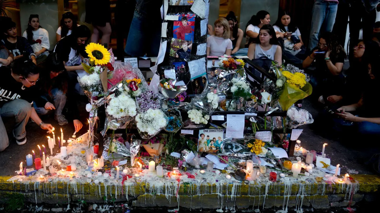 Fans von Liam Payne versammeln sich um eine Gedenkstätte vor dem Hotel, in dem er nach einem Sturz von einem Balkon tot aufgefunden wurde. (Foto: Natacha Pisarenko/AP/dpa)