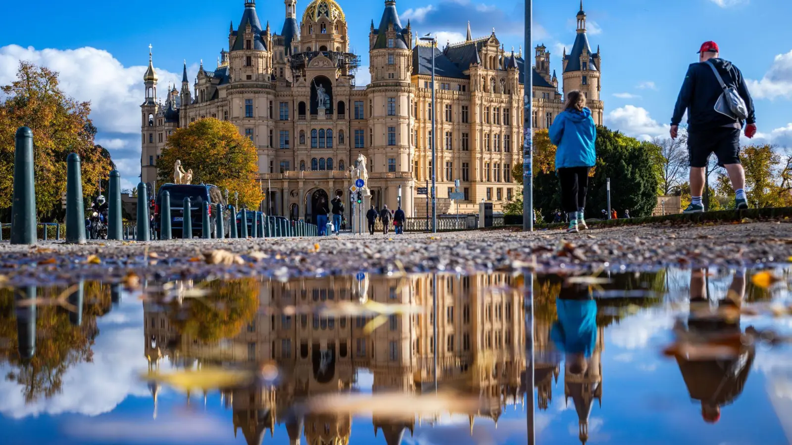 Milder Herbst: Schweriner Schloss spiegelt sich in einer Pfütze. (Foto: Jens Büttner/dpa)