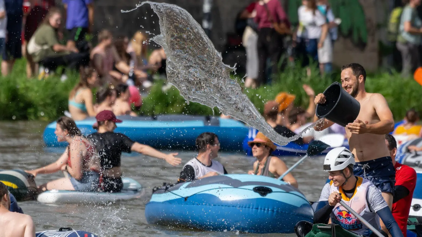 Das Wetter spielt mit: Junge Leute liefern sich auf der Donau beim Nabada eine Wasserschlacht. (Foto: Stefan Puchner/dpa)