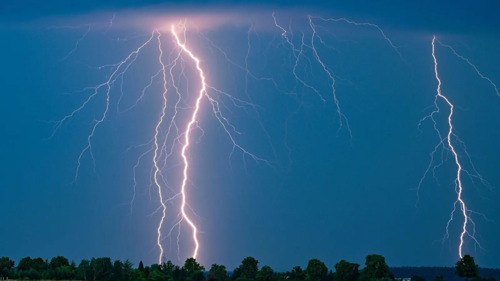 Schnell weg! Bei einem Gewitter muss man sich entweder in einem Gebäude in Sicherheit bringen - oder Schutz in einer Mulde suchen. (Foto: Patrick Pleul/dpa/dpa-tmn)