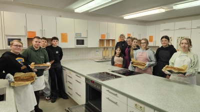 Frisch aus dem Ofen: Vier Dinkel-Vollkornbrote backen Achtklässler jede Woche in der Leutershäuser Schulküche, angeleitet von Lehrkraft Susanne Bergold (Fünfte von rechts). Dass Schüler für Schüler das Pausenbrot backen, freut auch Rektorin Caroline Ludwig-Schönig (Sechste von rechts). (Foto: Wolfgang Grebenhof)