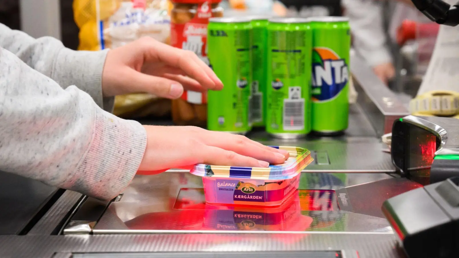 Eine Kassiererin scannt Lebensmittel an der Kasse eines Supermarktes. (Foto: Julian Stratenschulte/dpa)