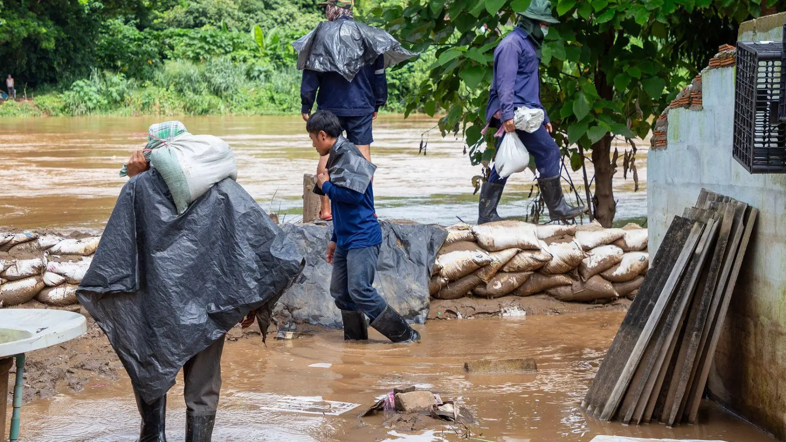 Mit Sandsäcken versuchten Helfer, die Fluten aufzuhalten. (Foto: Pongmanat Tasiri/SOPA Images via ZUMA Press Wire/dpa)