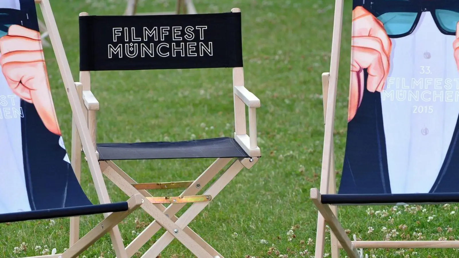 Liegestühle bedruckt mit dem Schriftzug „Filmfest München” stehen im Hof der Filmhochschule auf einer Wiese. (Foto: Ursula Düren/dpa)