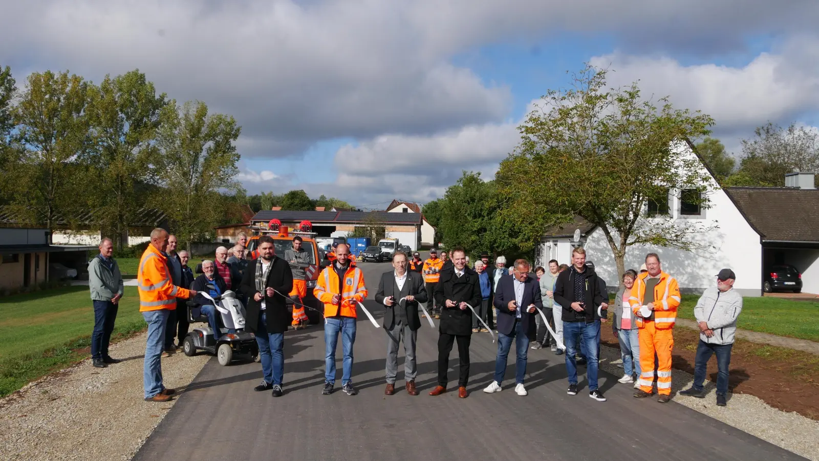 Das Band ist durchschnitten, die Straße aber erst in ein paar Tagen frei. Die Freihaslacher freuen sich zusammen mit den Behördenvertretern und Vertretern der Politik über den (fast) vollendeten ersten Bauabschnitt. (Foto: Ulli Ganter)