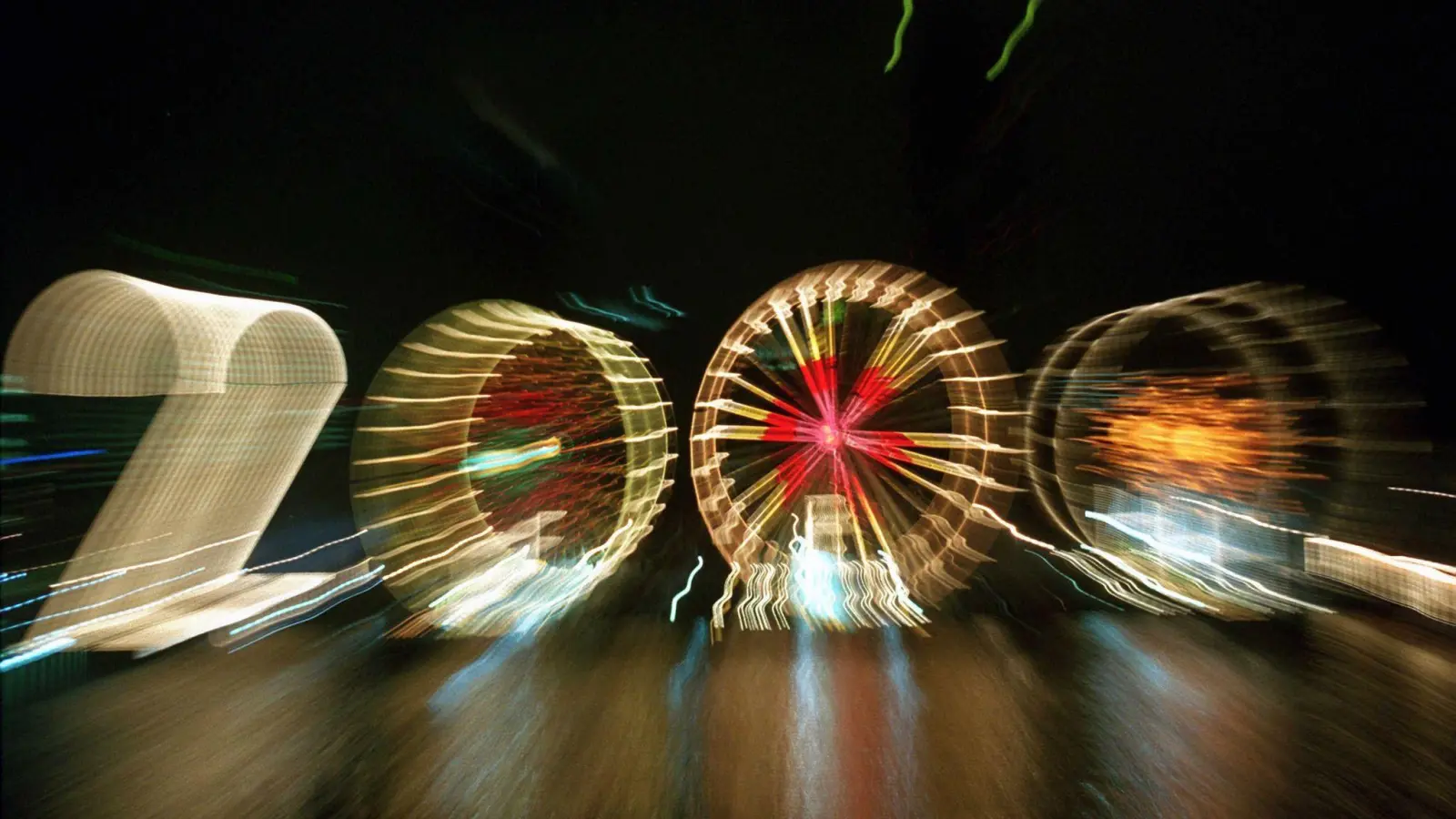 25 Jahre alt ist dieses „2000“-Foto: Ein Zoom-Effekt verfremdet eine große „2“ und drei Riesenräder am Mainufer in Frankfurt in der Silvesternacht 1999/2000.  (Foto: Arne Dedert/dpa)