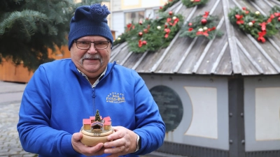 Fritz Heubeck zeigt vor dem Markgraf-Georg-Brunnen auf dem Martin-Luther-Platz seine Bastelarbeit für den Weihnachtsmarkt in Ansbach: eine Spieluhr. (Foto: Oliver Herbst)