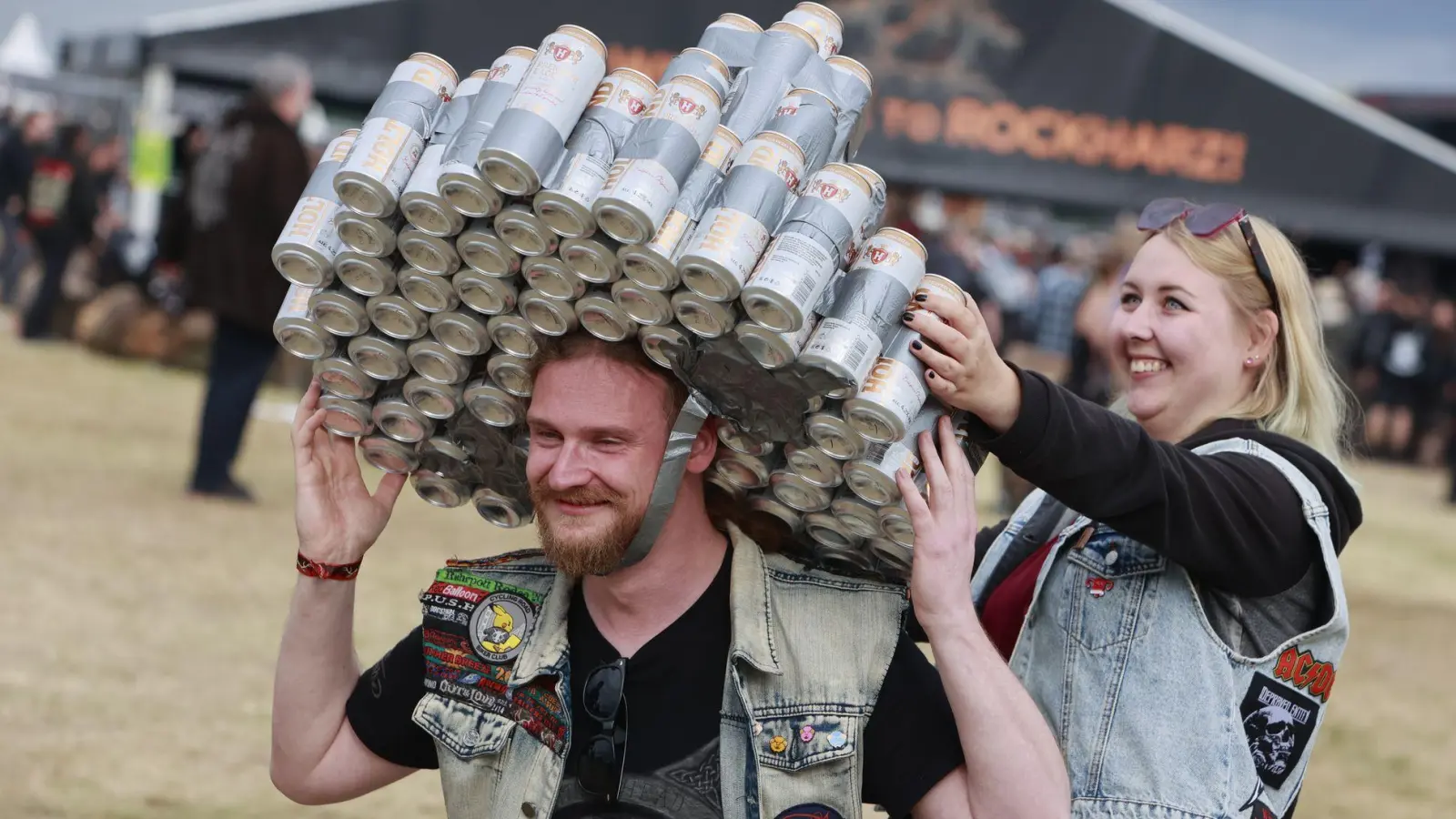 Gut behütet: Ein Besucher des Festivals Rockharz hat sich eine Kopfbedeckung aus Getränkedosen gebastelt und läuft über das Festivalgelände. (Foto: Matthias Bein/dpa)
