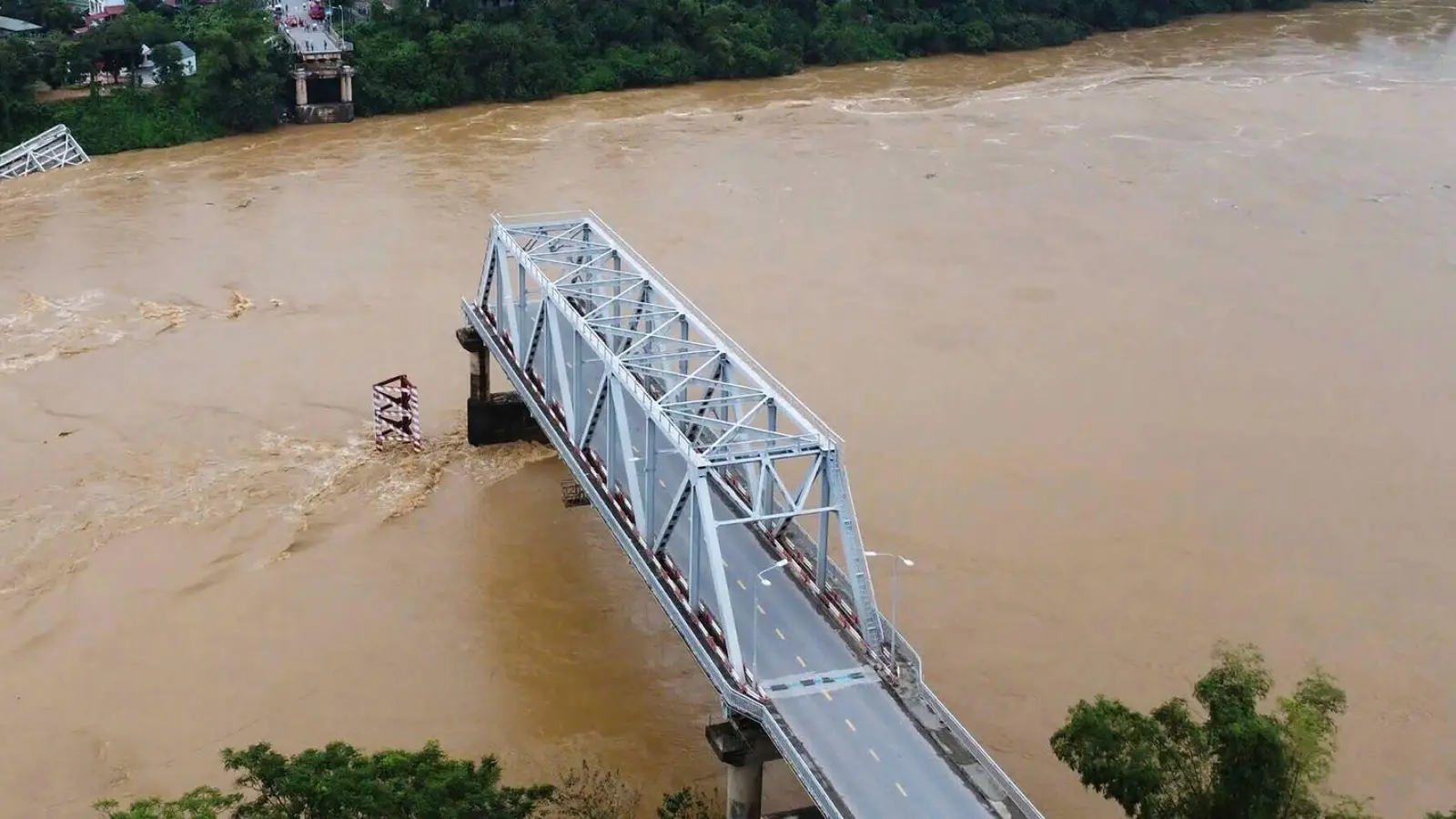 Ein Teil der Brücke stand noch, der Rest verschwand in kurzer Zeit in den Fluten. (Foto: Bui Van Lanh/VNA/AP/dpa)