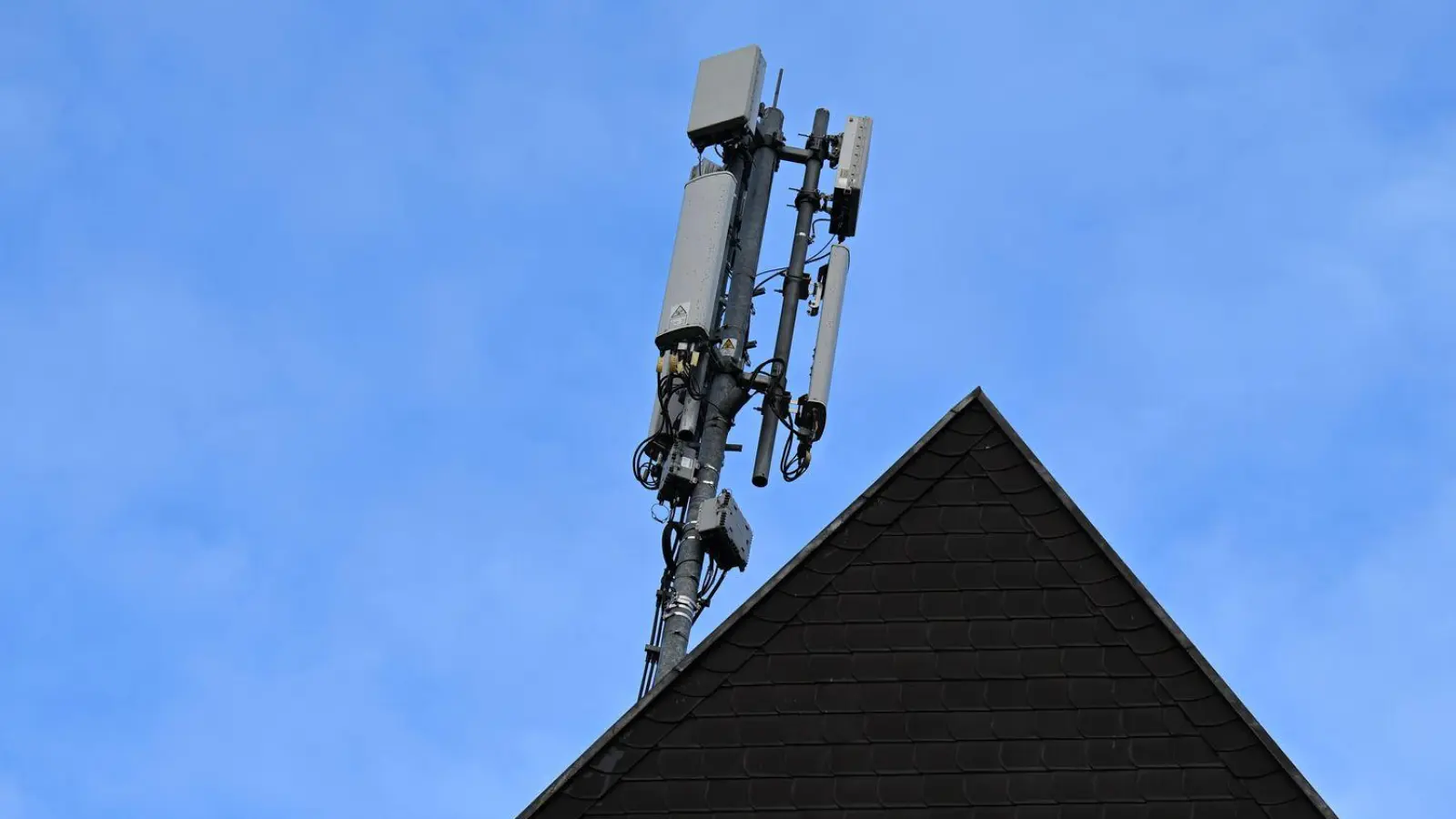 Ein Mobilfunk-Mast mit Antennen im Funkstandard 5G (quadratisch) und 4G (länglich) ist auf dem Dach eines Wohnhauses montiert. (Foto: Wolf von Dewitz/dpa)