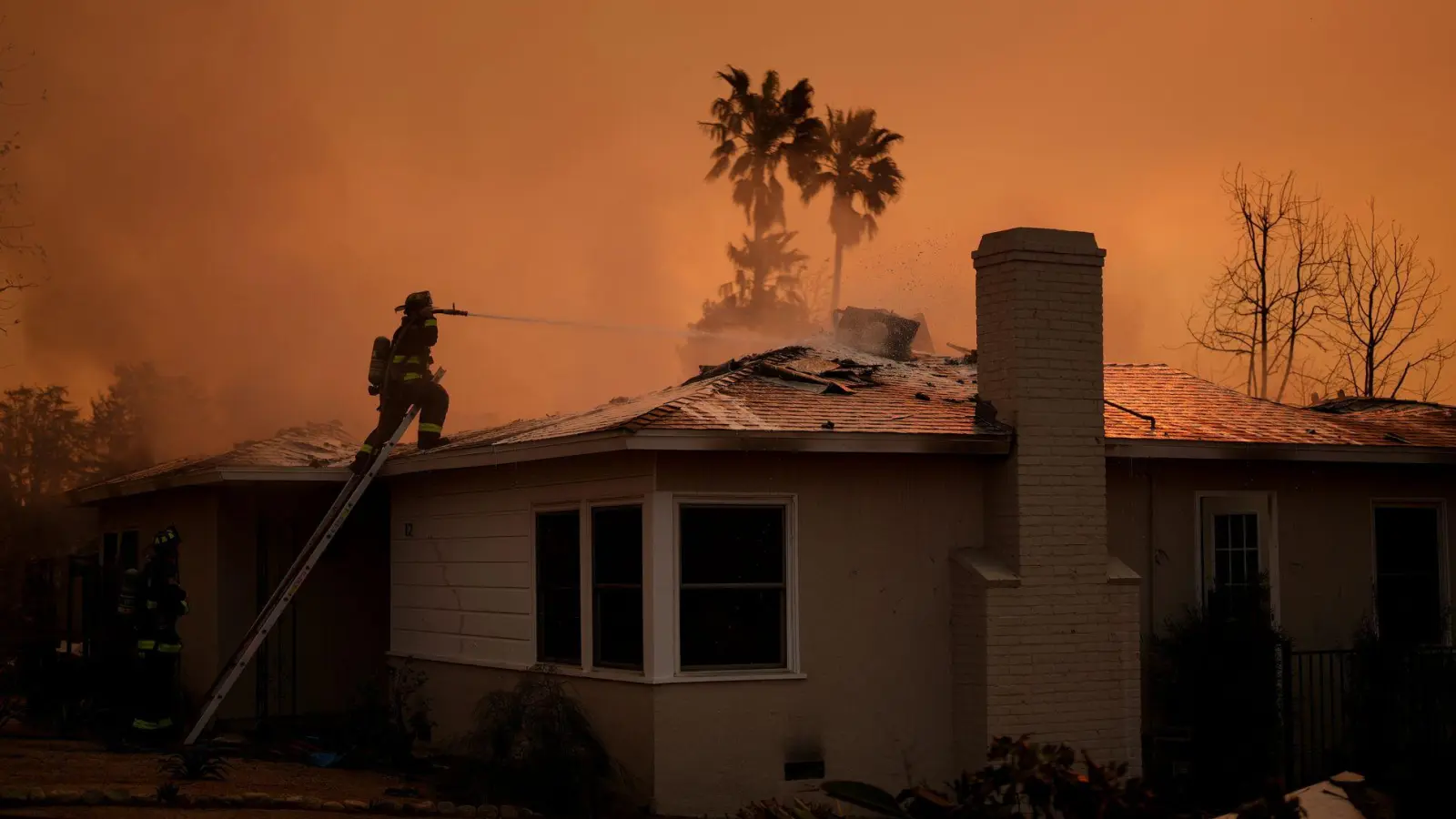 Im Dauereinsatz: Ein Feuerwehrmann versucht, ein Wohnhaus vor den Flammen des „Eaton Fire“ zu bewahren. (Foto: Eric Thayer/AP/dpa)