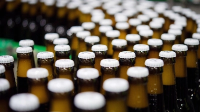 Bierflaschen mit Kronkorken laufen durch die Produktion der Veltins-Brauerei in Meschede-Grevenstein über die Förderbänder einer Befüllungsanlage. (Foto: Rainer Jensen/dpa)