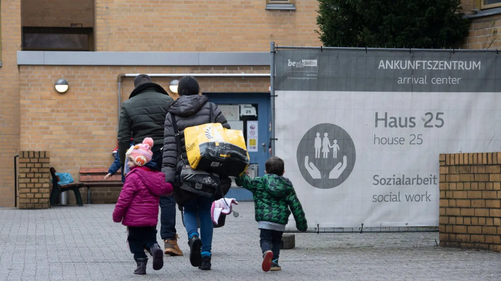 Eine geflüchtete Familie betritt eine Erstaufnahmestelle in Berlin-Reinickendorf. (Foto: Paul Zinken/dpa)