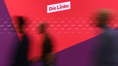 Besucher des Parteitages laufen an dem neuen Logo der Partei die Linke vorbei. (Foto: Karl-Josef Hildenbrand/dpa)