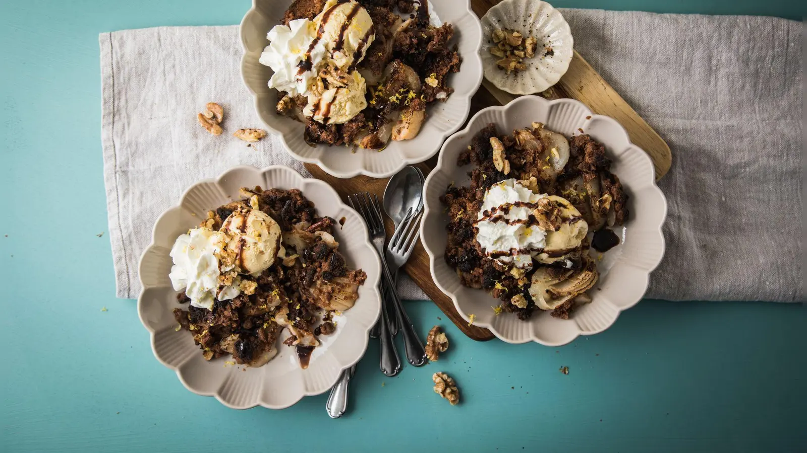 Der Birnen-Schokolade-Crumble lässt sich mit Vanilleeis, Sahne, Schokoladensoße, Zitronenzesten und Walnüssen lecker anrichten.  (Foto: Christin Klose/dpa-tmn)