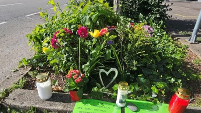 Blumen und Grablichter sind an der Unfallstelle aufgestellt worden. (Foto: Andreas Rosar/dpa)