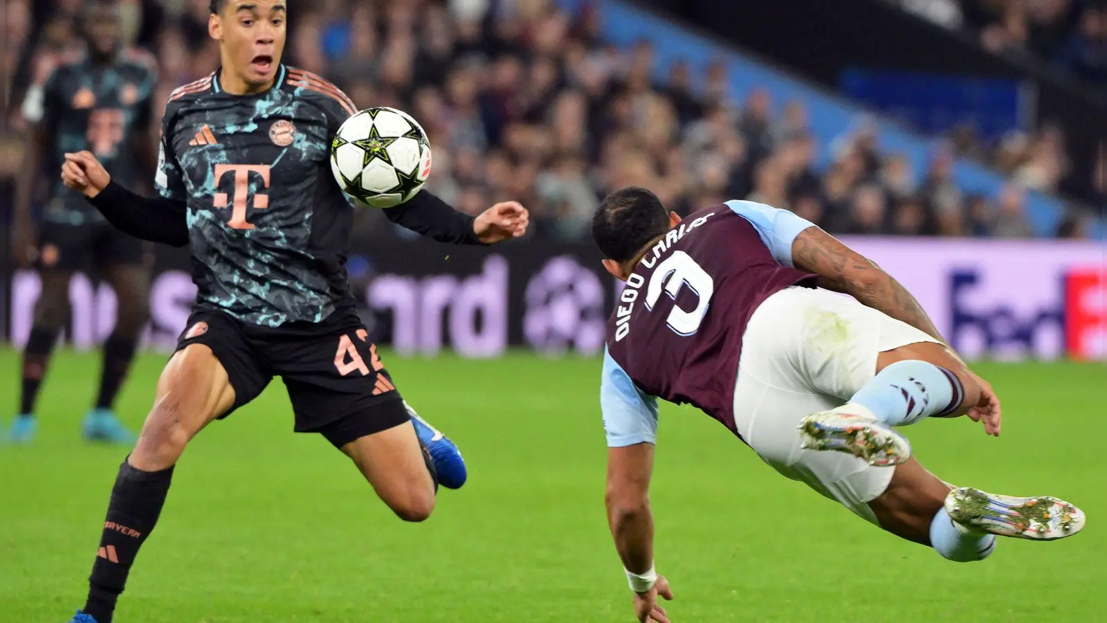 Jamal Musiala (l), hier im Einsatz gegen Aston Villa, muss vorerst pausieren. (Foto: Peter Kneffel/dpa)