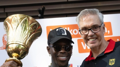 Dennis Schröder (l) und Basketball-Bundestrainer Gordon Herbert mit dem WM-Pokal. (Foto: Boris Roessler/dpa)