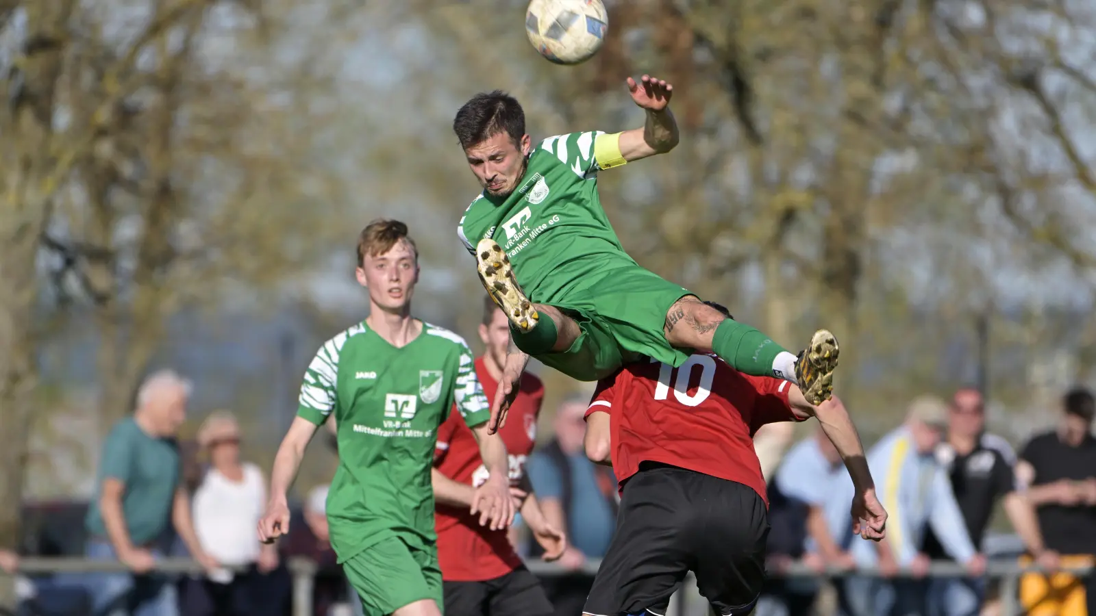 Ausgehebelt: Den SV Arberg (in Rot mit Thomas Weinmann) als Konkurrent muss der FC/DJK Burgoberbach (oben Gianni Böttcher) nicht mehr fürchten, die Arberger sind aufgestiegen. Ist der Weg nun frei für die Collins-Mannschaft? (Foto: Martin Rügner)