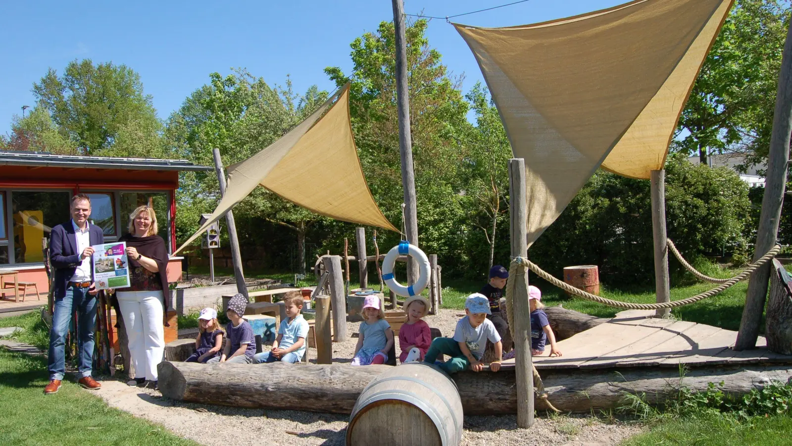 Vor dem bei den Kinder beliebten Piratenschiff freuten sich die Leiterin der Kindertagesstätte Diespeck, Barbara Hartmann und Bürgermeister Dr. Christian von Dobschütz zusammen mit einigen Kindern, dass die Diespecker Einrichtung unter den 15 Nominierten der Kategorie „Kita des Jahres“ ist. (Foto: Christa Frühwald)