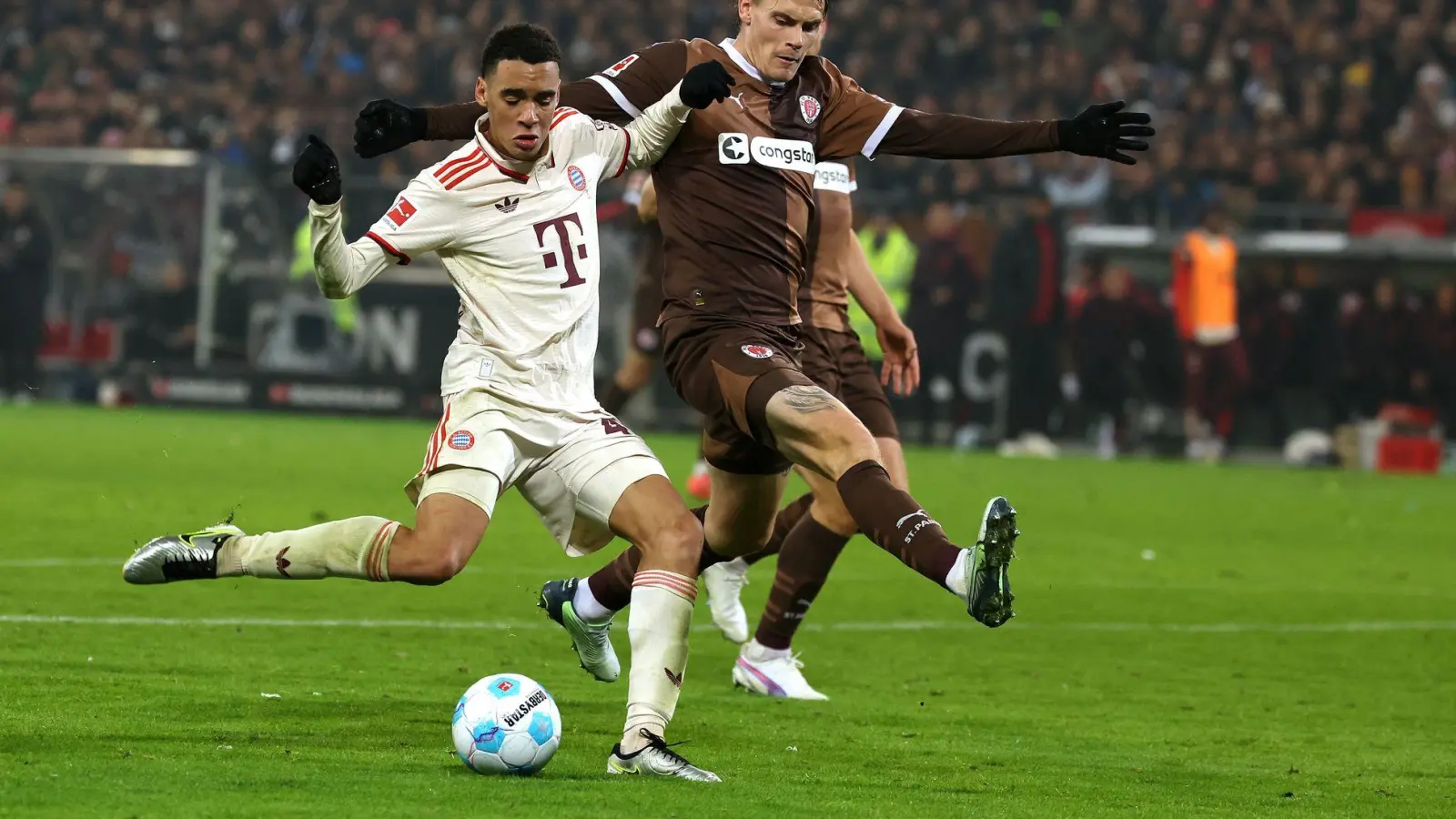 FC St. Paulis Abwehrspieler Eric Smith (r) verletzt sich beim Spiel gegen den FC Bayern.   (Foto: Christian Charisius/dpa)