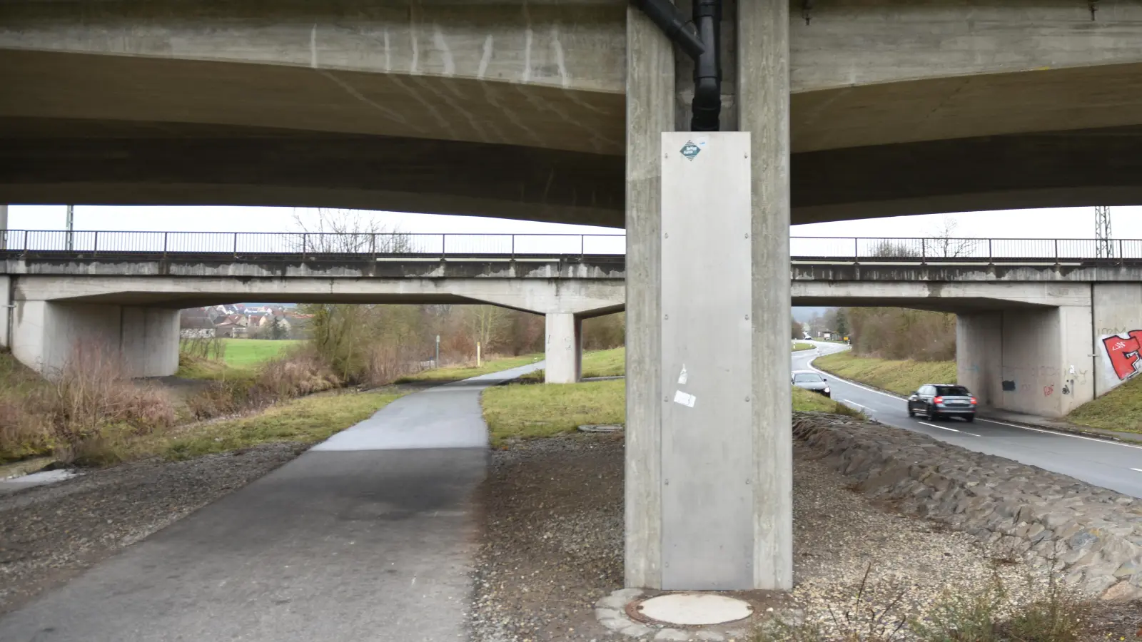 Vorne die B8-Brücke, hinten die Bahnbrücke. Der Radweg und die tiefer liegende Staatsstraße 2256 bilden das Nadelöhr. In der Erde liegen viele Leitungen und Leerrohre.  (Foto: Anita Dlugoß)