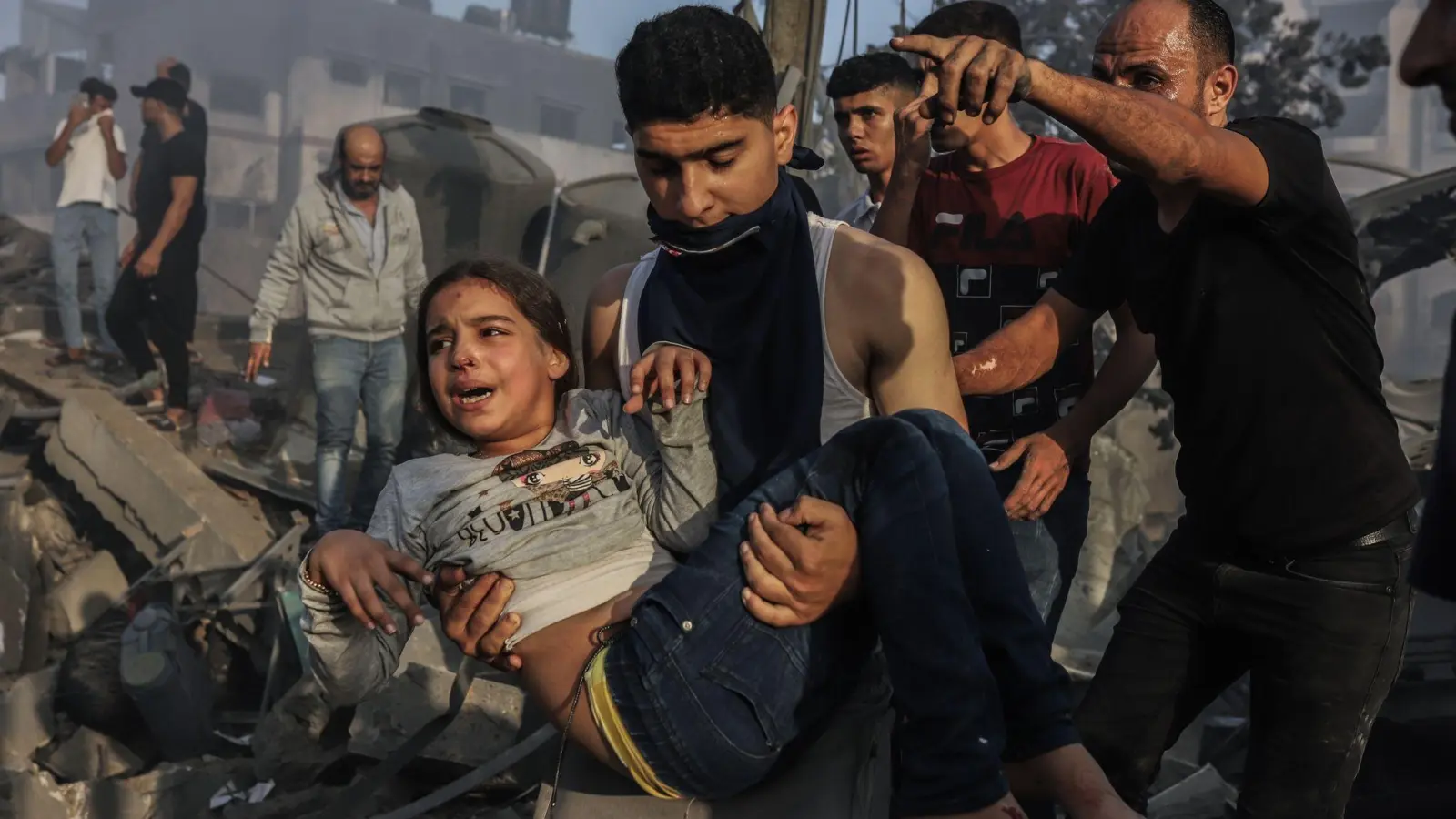 Palästinenser retten ein junges Mädchen aus den Trümmern eines zerstörten Gebäudes nach einem israelischen Luftangriff. (Foto: Mohammed Abu Elsebah/dpa)