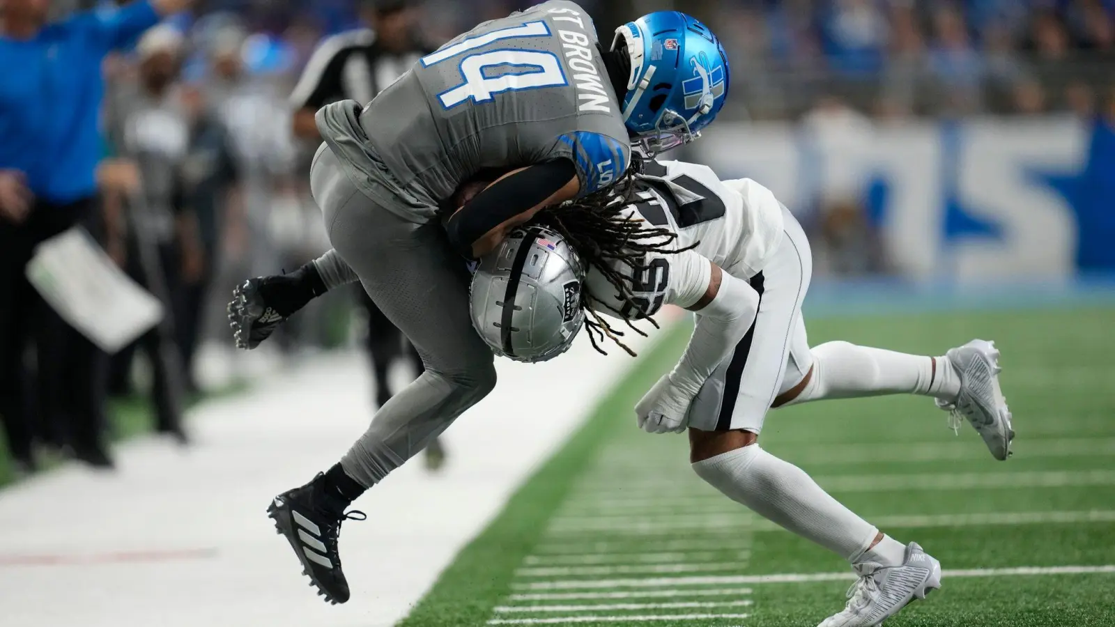 Detroit Lions Wide Receiver Amon-Ra St. Brown (14) wird von Las Vegas Raiders Safety Tre&#39;von Moehrig (25) aus dem Spielfeld gedrängt. (Foto: Paul Sancya/AP)